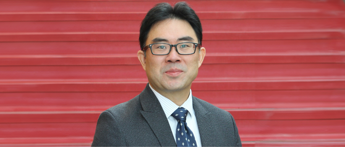 Dr. Brodie Sakakibara in front of a red background